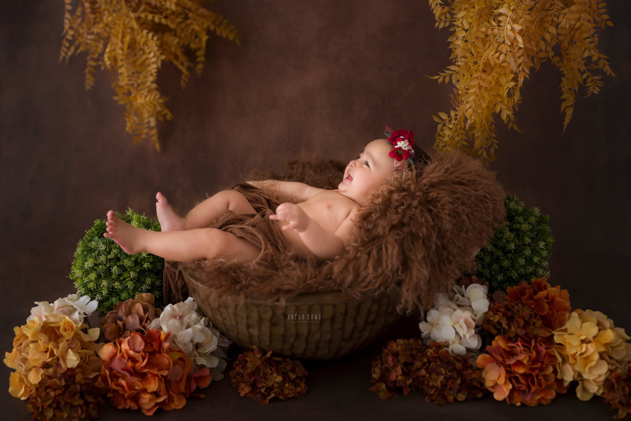 Baby girl photo shoot, 6 or 5 or 3 or 4 months, brown rug, orange and yellow flowers, cute headband. Location: Delhi, Gurgaon, Noida. Photographer: Anega Bawa.