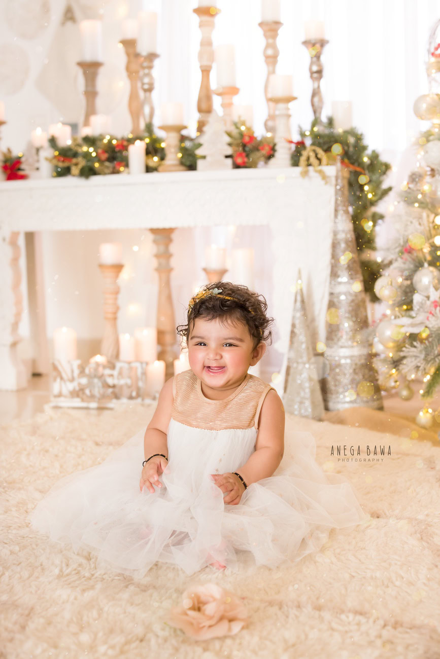 Capture the adorable innocence of your baby girl aged 3, 4, 5, or 6 months with a charming photoshoot featuring candles in the backdrop, set against a beige rug and a white backdrop. Contact Anega Bawa, the expert baby girl photographer in Delhi, Gurgaon, or Noida, to immortalize these precious moments.
