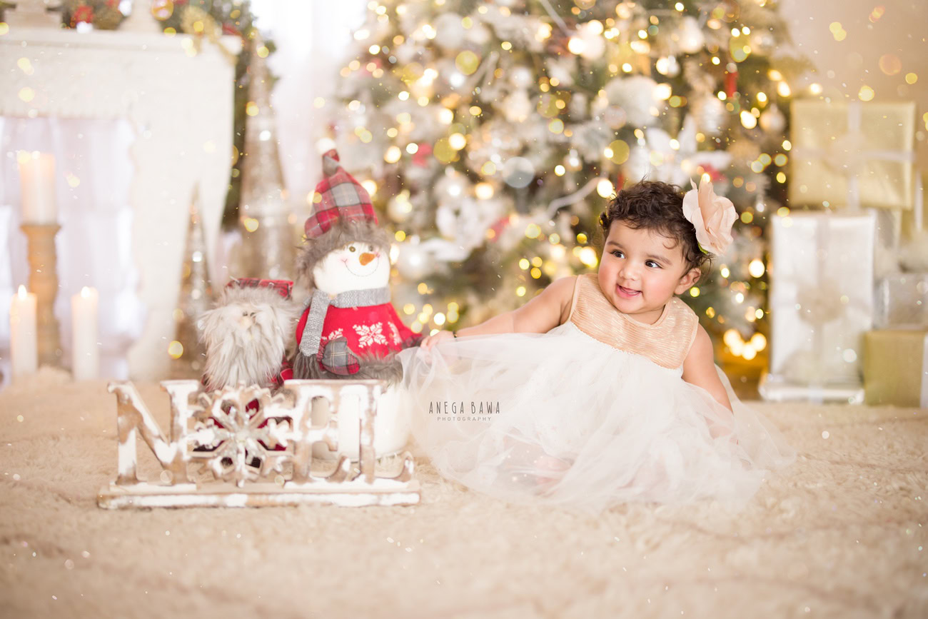 Illuminate the joy of your baby girl's growth with a festive touch! Capture her charm at 3, 4, 5, or 6 months amidst the warmth of golden lights and the coziness of a beige rug, set against the backdrop of a Christmas tree. Contact Anega Bawa, your trusted baby girl photographer in Delhi, Gurgaon, or Noida, to make these moments last forever.