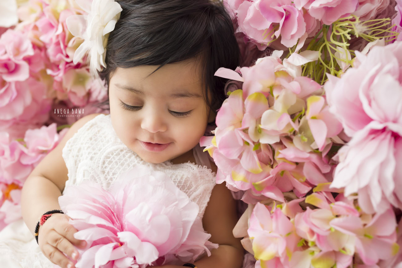 Experience the charm of your little one posing against a delightful floral backdrop. Choose Anega Bawa for memorable baby girl photography sessions in Delhi, Gurgaon, or Noida.