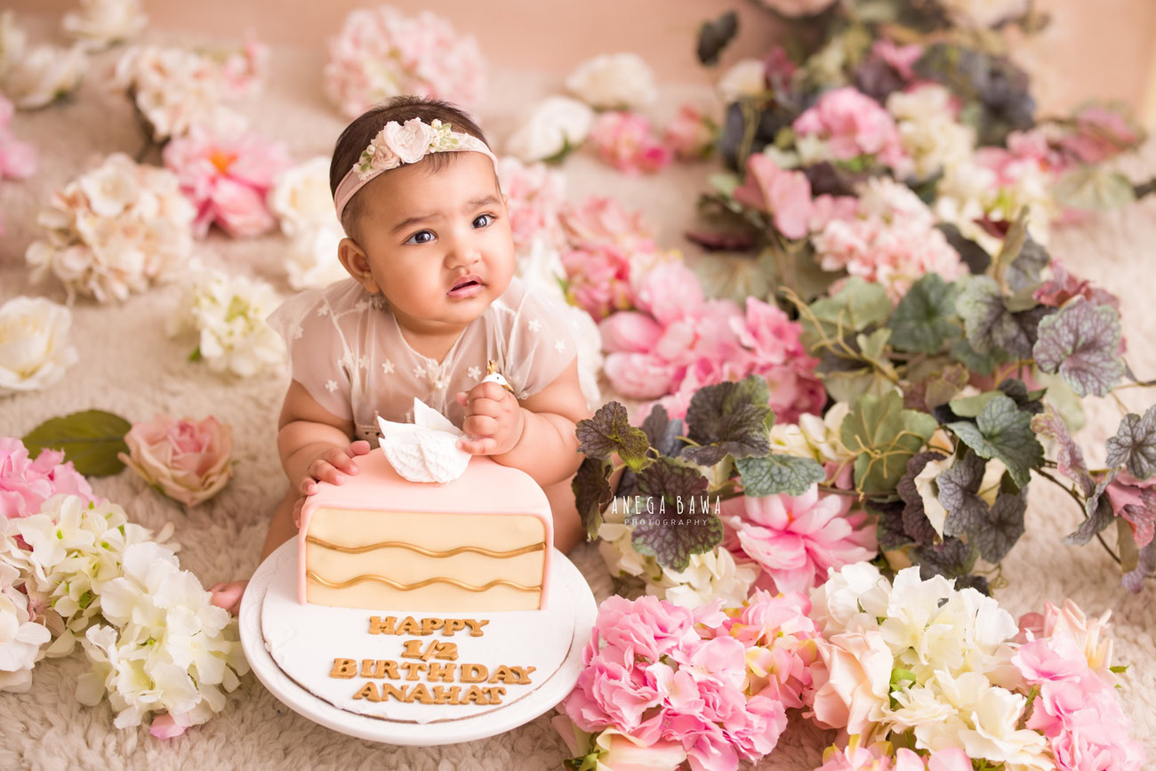 Celebrate your baby girl's growth with a delightful cake smash photoshoot featuring a beige top and headband against a cozy beige backdrop. Contact Anega Bawa for capturing these cherished moments in Delhi, Gurgaon, or Noida.