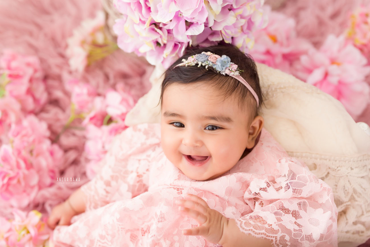 Create timeless memories with your baby girl aged 3, 4, 5, or 6 months in an adorable baby pink dress against a charming pink backdrop, adorned with a cute headband. Book your session with Anega Bawa in Delhi, Gurgaon, or Noida.