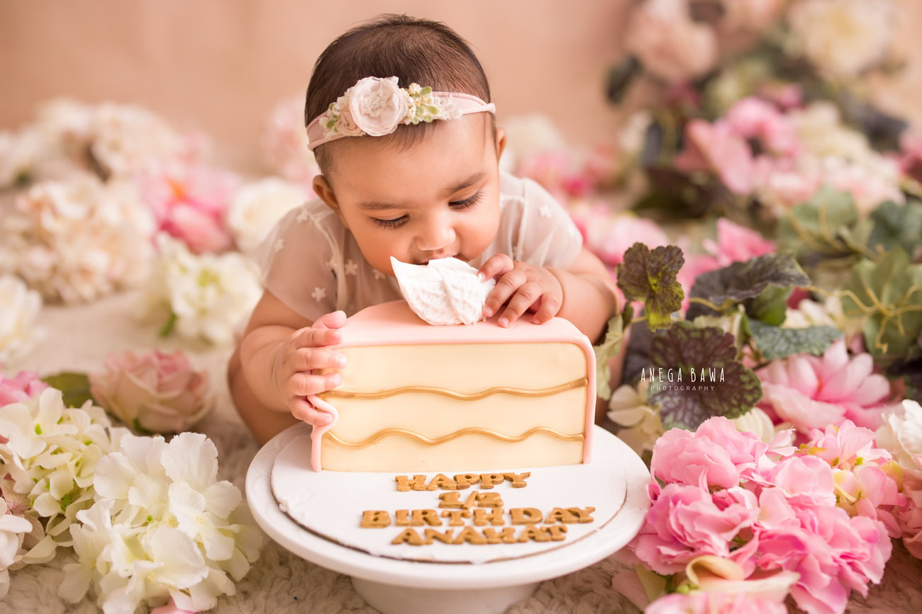 Celebrate your little one's milestones with a heartwarming photoshoot! Featuring a peach backdrop adorned with multicolored flowers, this session promises sweet memories and delightful moments, including a fun cake smash. Contact Anega Bawa for this special experience in Delhi, Gurgaon, or Noida.