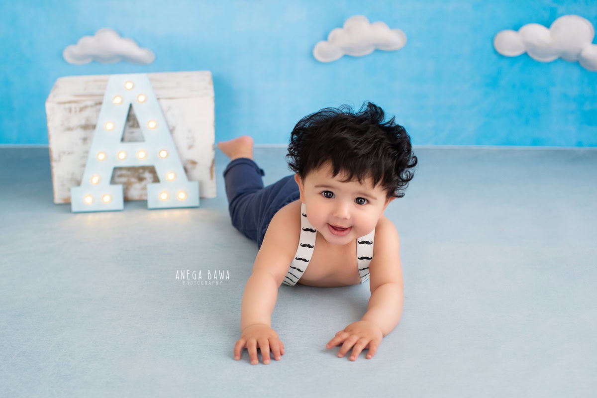 In an enchanting photo captured by talented sitter photographer Anega Bawa in Delhi, a precious 8-month-old boy crawls on a floor with a cloudy backdrop, surrounded by an alphabet frame resting on the floor.