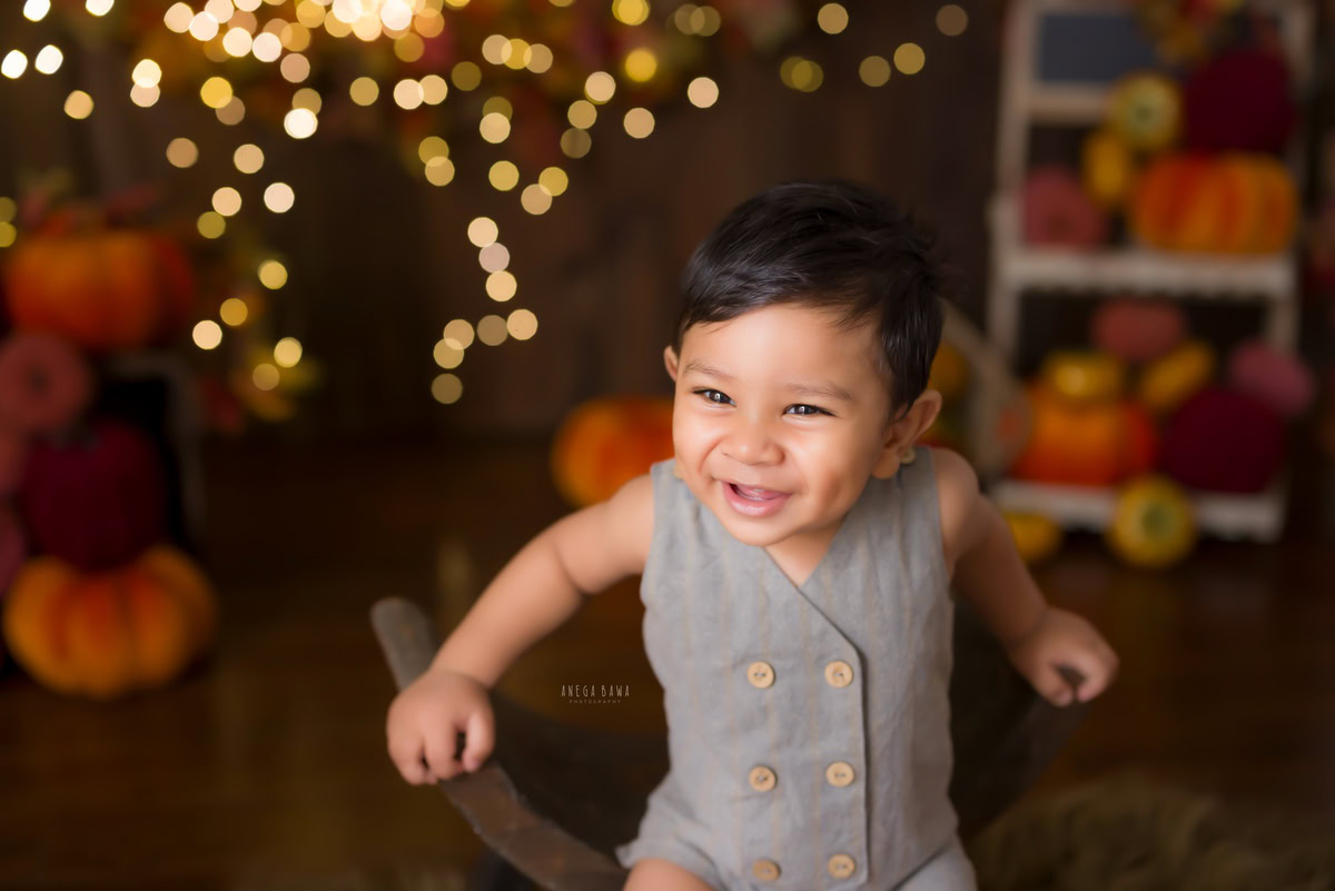 Witness the enchanting innocence of your little one with Anega Bawa Photography in Delhi and Gurgaon. In this captivating sitter photoshoot, your child, aged approximately 10 months to 1 year, sits gracefully on a curvy chair. Against a rustic brown backdrop illuminated by gentle fairy lights, each moment is imbued with warmth and charm. Let us preserve these precious memories as your child explores the world around him with wonder and curiosity.