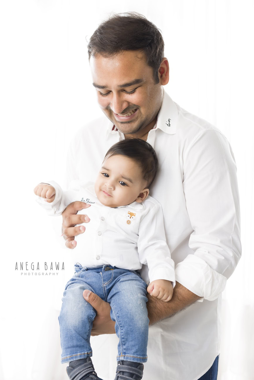 Capture the bond between father and son with Anega Bawa Photography in Delhi and Gurgaon. Dress your 5-month-old son in a crisp white shirt as you both pose against a clean white backdrop, creating timeless memories that celebrate the love and connection of your family.