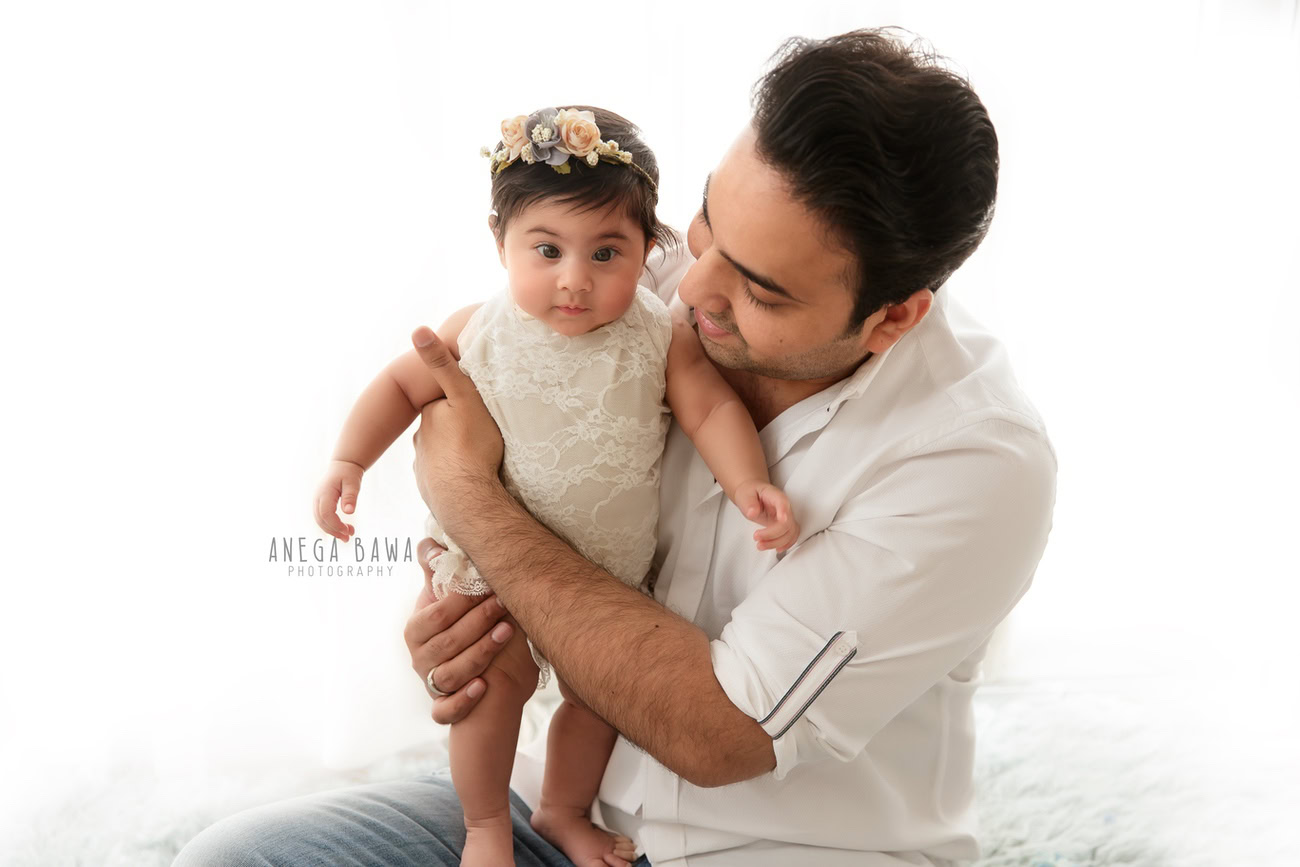 Create beautiful memories with Anega Bawa Photography in Delhi and Gurgaon as Dad and daughter pose in a delightful duo, adorned with cute tiara bands, against a pristine white backdrop. Capture the essence of their special bond in every frame.