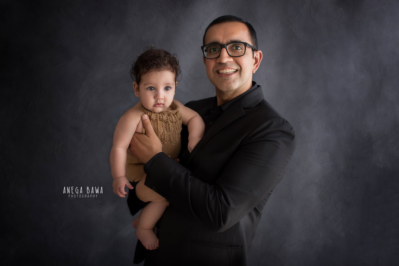 Capture the precious moments of Dad and daughter bonding against a soft grey backdrop with Anega Bawa Photography in Delhi and Gurgaon. Let their love shine through in timeless photographs.