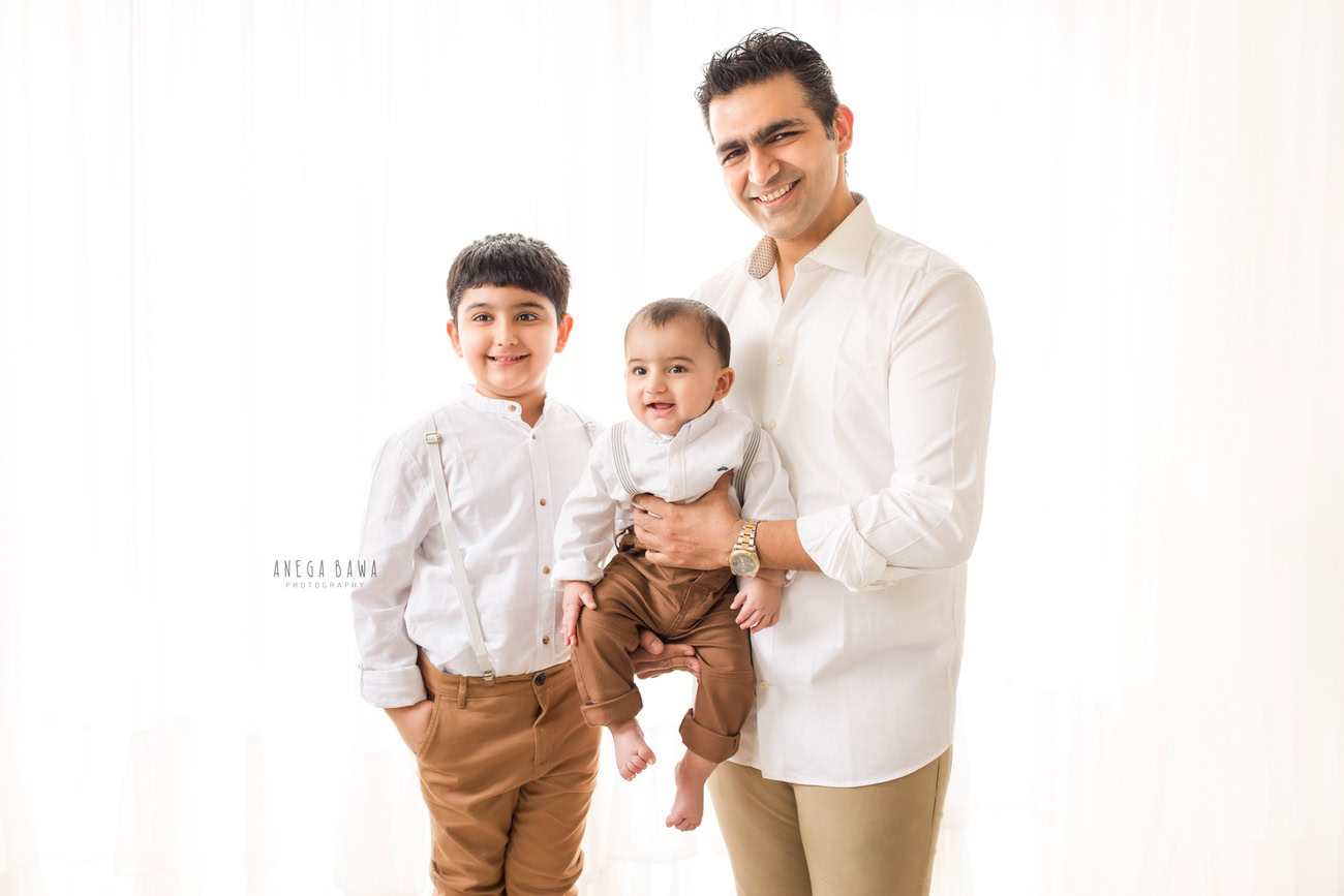 In the heart of Delhi and Gurgaon, Anega Bawa Photography captures the bond between a father and his 5-year-old son in timeless elegance. Dressed in beige trousers and a crisp white shirt against a pristine white backdrop, their love shines through in every frame, creating cherished memories for years to come.