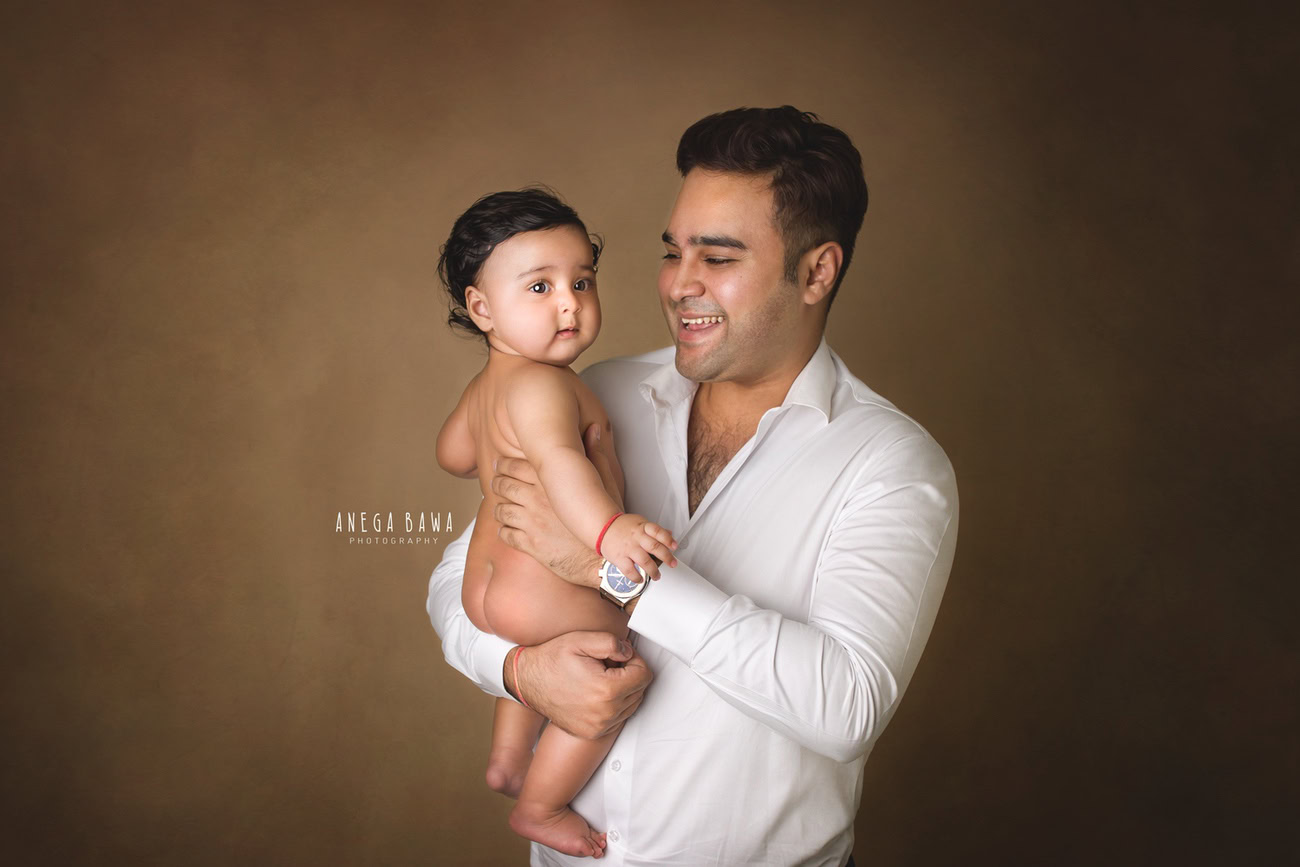 In Delhi and Gurgaon, against a warm brown backdrop, Anega Bawa Photography captures the pure joy of father and son in a delightful and heartwarming smile, freezing a moment that radiates happiness and love.