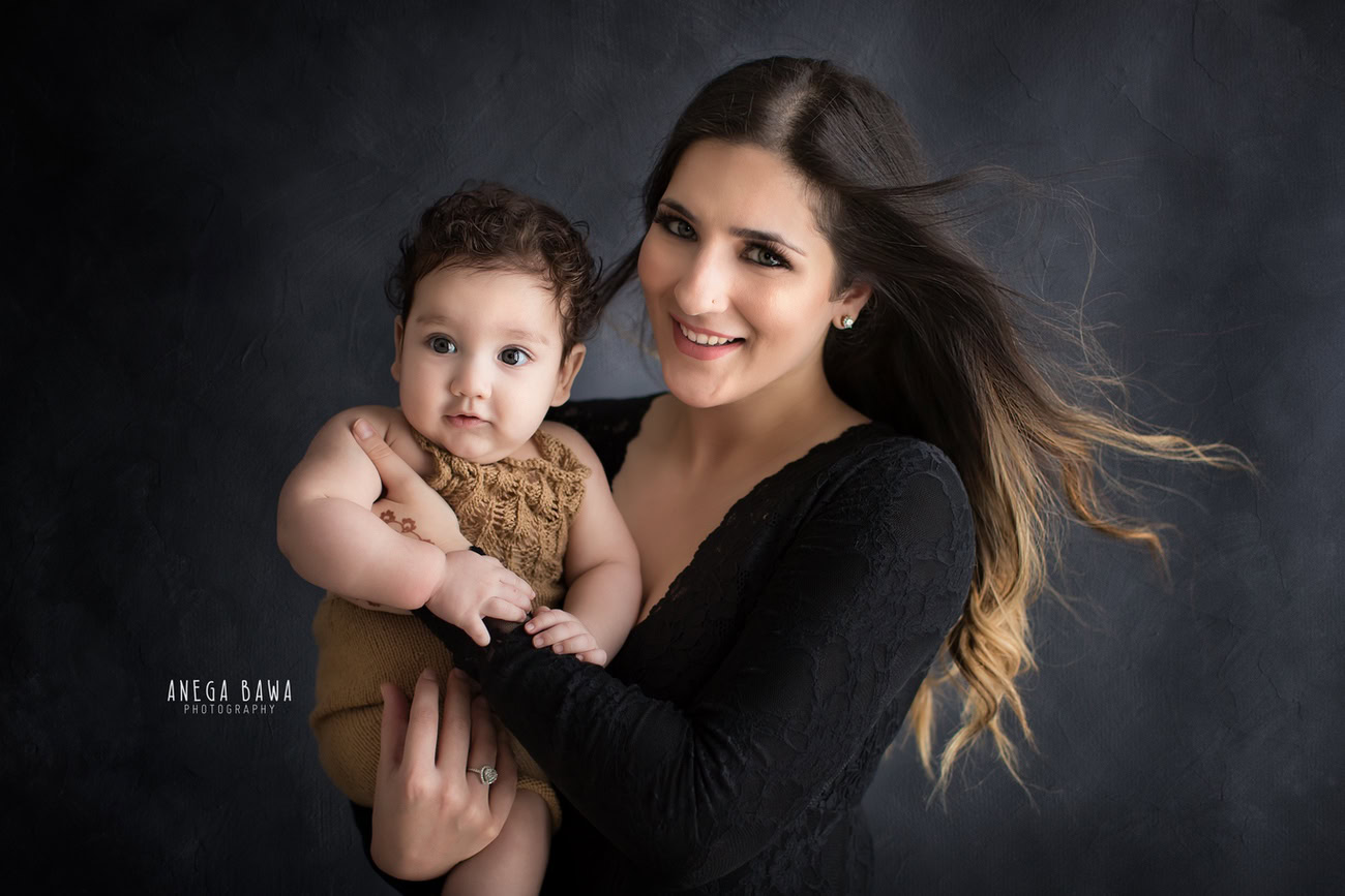 Captivating family photoshoot by Anega Bawa Photography, recognized in Delhi and Gurgaon, featuring the charming duo of Mom and daughter against a stylish grey backdrop.