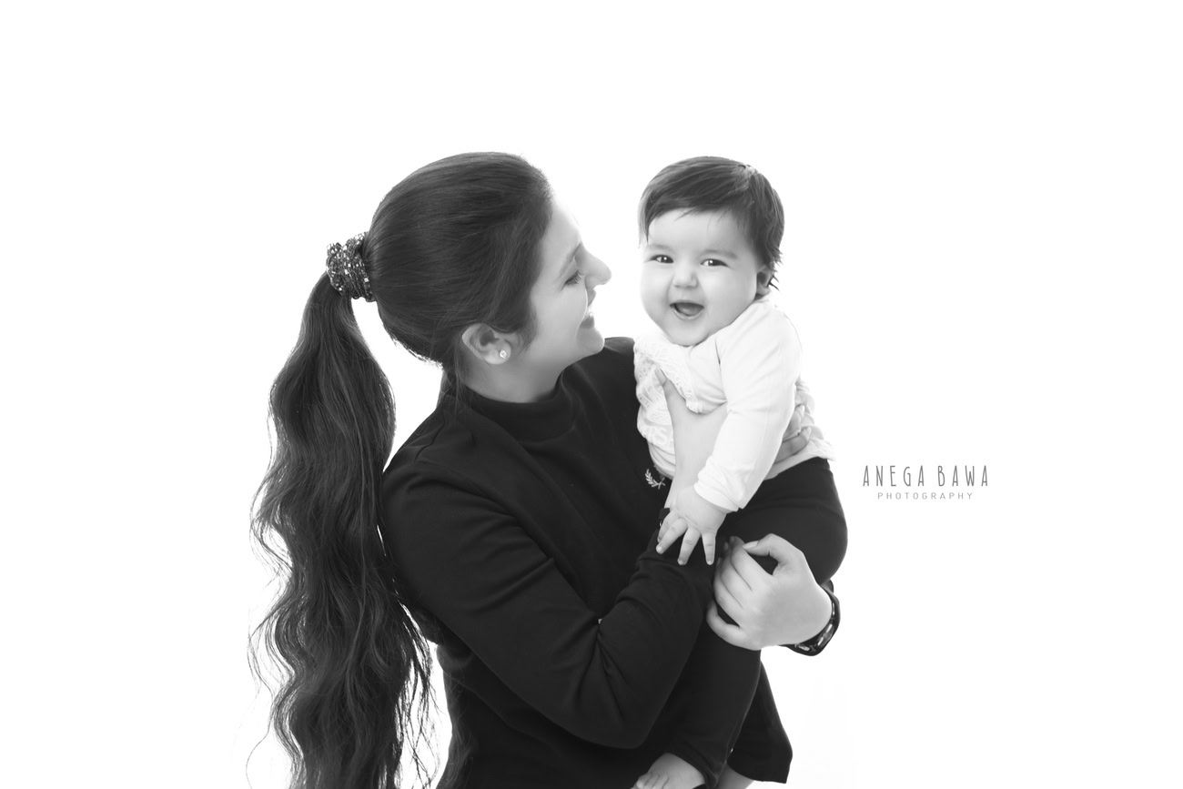 Create timeless memories with a delightful family photoshoot capturing the affection between a mother and her son, set against a pristine white backdrop. With Anega Bawa Photography in Delhi and Gurgaon, cherish each precious smile and tender moment.