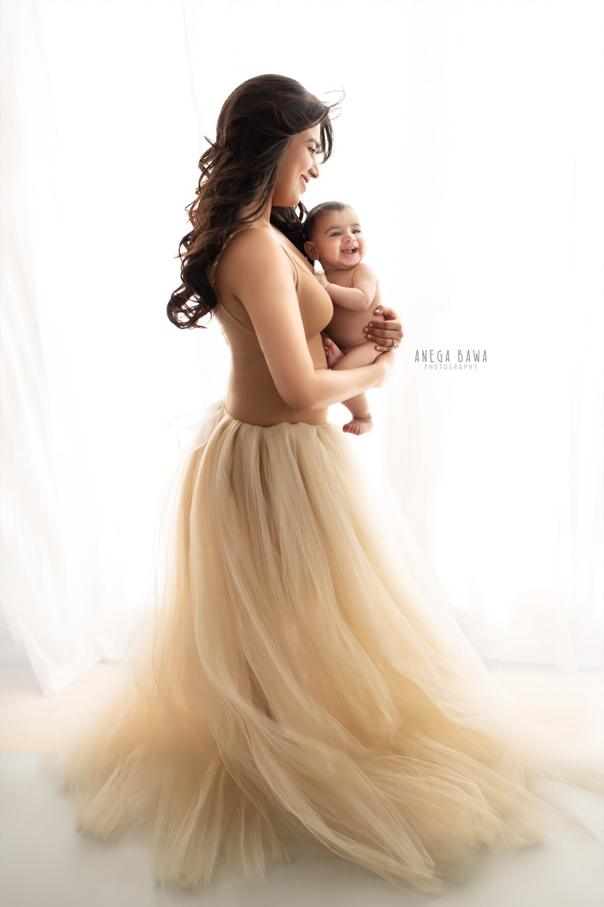 Indulge in the tender bond shared by a mother and her son, as they pose elegantly against a crisp white backdrop, captured by Anega Bawa Photography in Delhi and Gurgaon. Witness the magic unfold as the duo shines in Mumma's beige net dress, creating timeless memories to cherish forever.