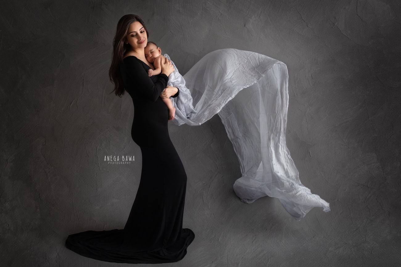 Capture the purest moments of love with a heartwarming family photoshoot by Anega Bawa Photography in Delhi and Gurgaon. Watch as Mumma cradles her daughter tenderly in a white wrap, their bond immortalized in a classic black-and-white pose against the backdrop of timeless elegance.