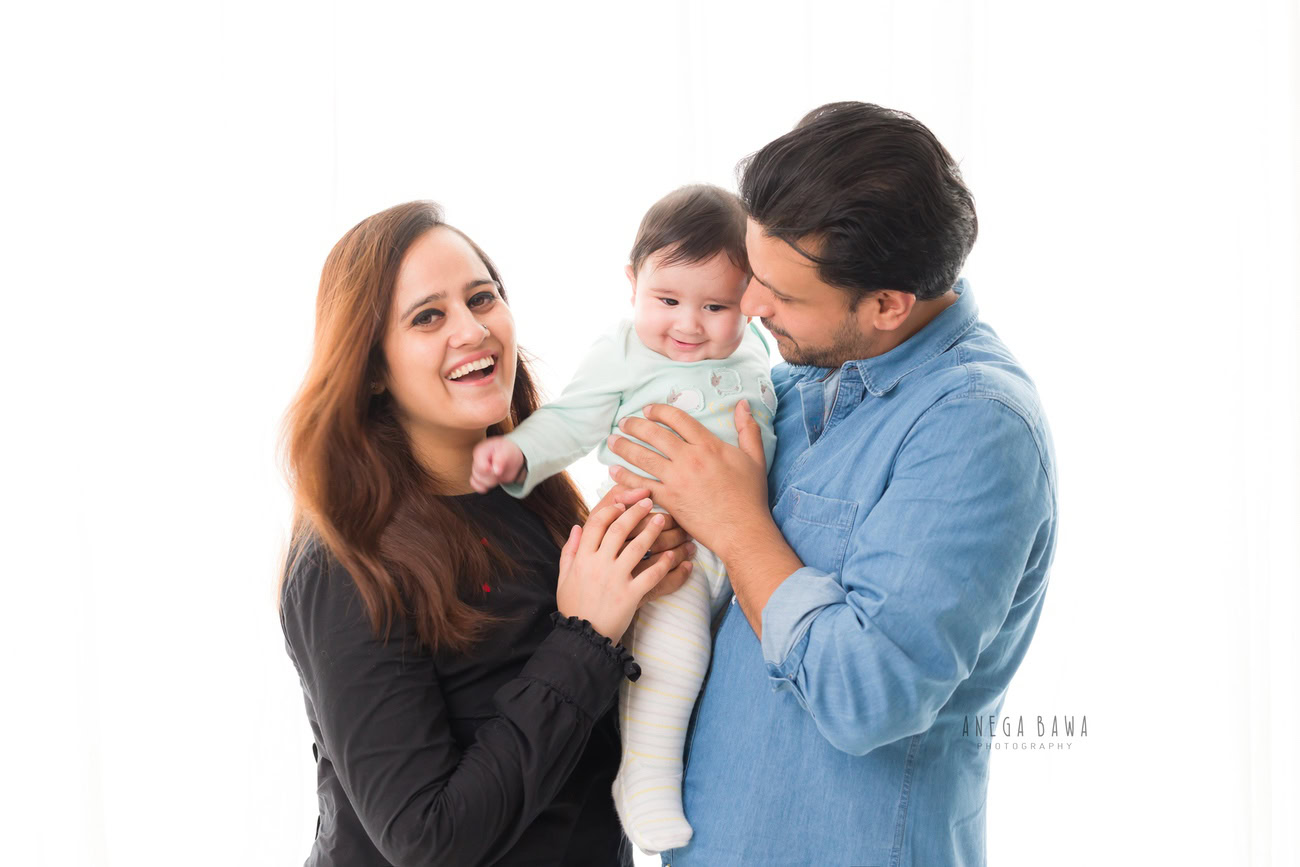 Create everlasting memories with your family at Anega Bawa Photography in Delhi and Gurgaon. Cherish those tender moments as Mumma and Papa pose with their adorable daughter against a serene white backdrop. These precious snapshots will be treasured for years to come.