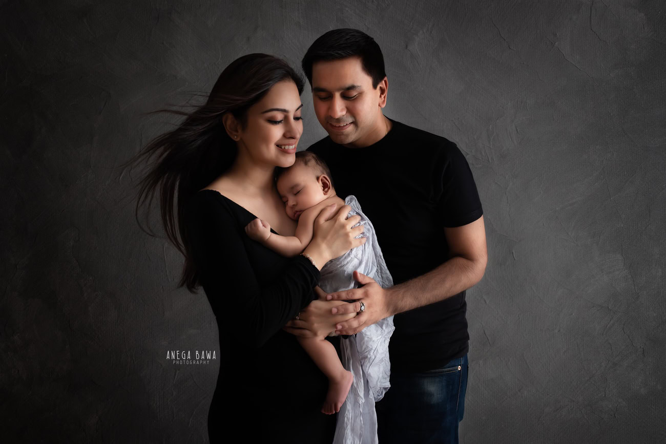 Embrace the timeless elegance of black and white photography in your family photoshoot with Anega Bawa Photography in Delhi and Gurgaon. Mumma and Papa can wear black attire, enveloping their daughter in a warm and affectionate hug. This classic pose against a backdrop of choice captures the bond and love shared within your family, immortalizing the moment in a beautiful monochromatic frame.