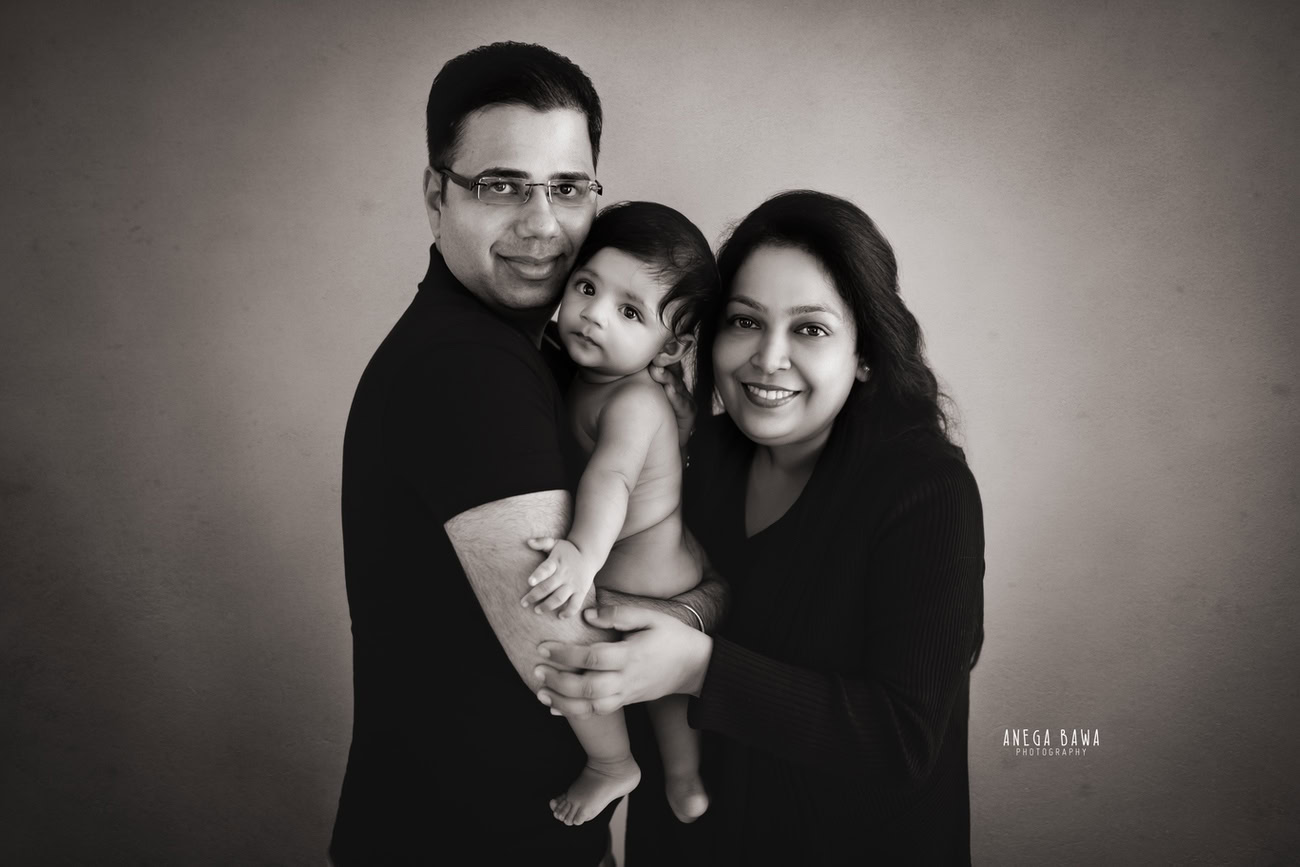 Capture the essence of timeless beauty and familial love with Anega Bawa Photography in Delhi and Gurgaon. Dress Mumma and Papa in elegant black attire, creating a striking contrast against a black-and-white backdrop. With your adorable boy in between, this classic setup not only highlights your family's style but also immortalizes your bond in a stunning monochromatic frame.