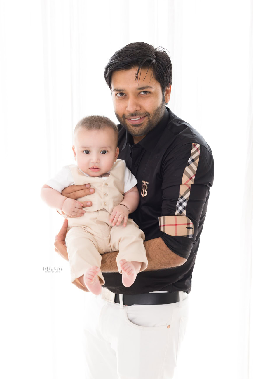 Celebrate the bond between father and son with Anega Bawa Photography in Delhi and Gurgaon. Let the love and joy shine through as the father holds his precious son against a pristine white backdrop, capturing the essence of this beautiful relationship. These moments are precious and deserve to be preserved for a lifetime.