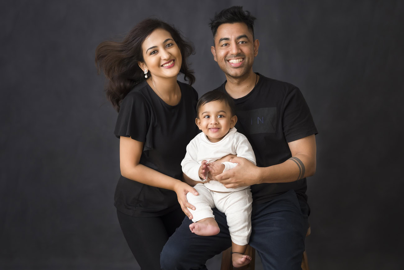 Create timeless memories with Anega Bawa Photography in Delhi and Gurgaon as your little one dons a charming white suit while posing with mom and dad, who are dressed in stylish black tees, against a sleek black backdrop. Capture the love and joy of your family in stunning photographs that you'll cherish forever.