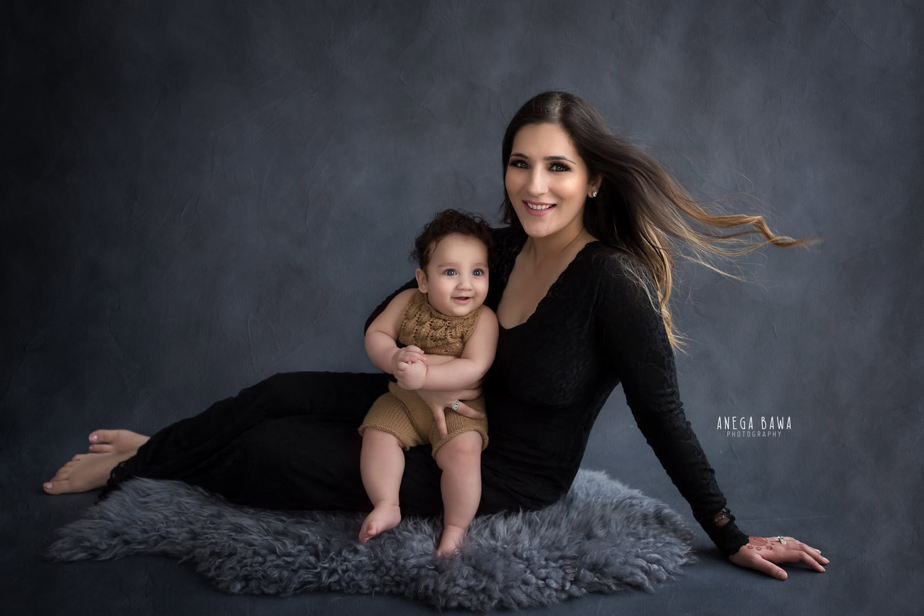 A family photoshoot featuring the mom and daughter sitting on a cozy grey rug against a serene grey backdrop sounds like a heartwarming scene. Anega Bawa Photography in Delhi and Gurgaon can capture the tender moments between mother and daughter, preserving them in timeless photographs to be cherished for years to come.