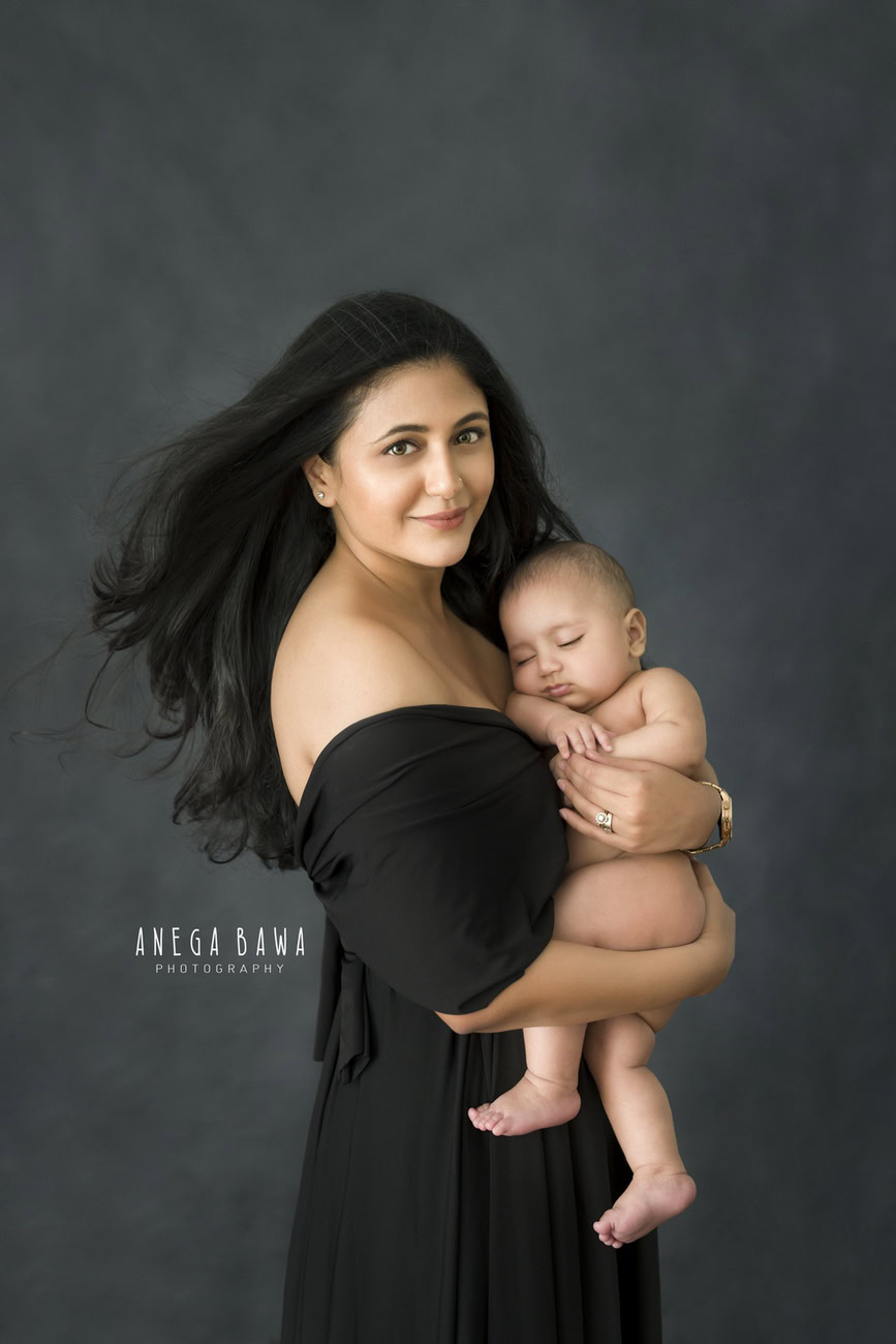 A family photoshoot capturing the tender moment of a mom and son in a cute hugging pose against a grey backdrop would be heartwarming. Anega Bawa Photography in Delhi and Gurgaon specializes in creating beautiful and memorable images that reflect the love and bond between family members. Their expertise in capturing emotions in a natural and artistic way ensures that your photos will be cherished for years to come.