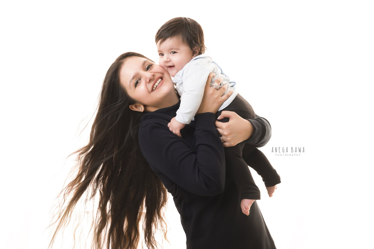 Experience the joy of family bonds with Anega Bawa Photography in Delhi and Gurgaon. Capture heartwarming moments of Mom and Son in a cute smiling pose against a pristine white backdrop, creating timeless memories to cherish forever.