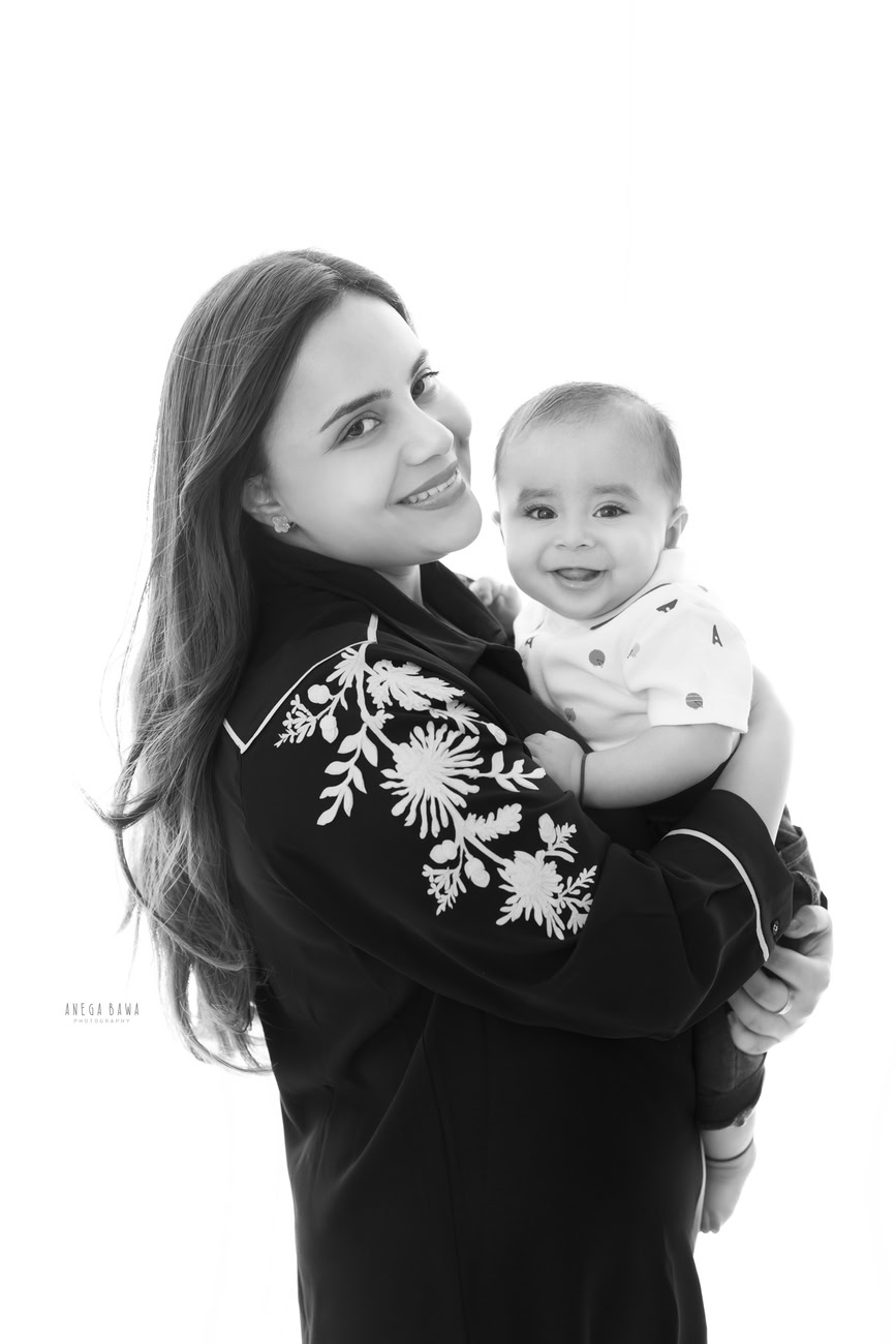 Capture timeless moments with Anega Bawa Photography in Delhi and Gurgaon. Cherish the bond between Mumma and her son as she holds him tenderly against a pure white backdrop, immortalizing the love and joy of motherhood.
