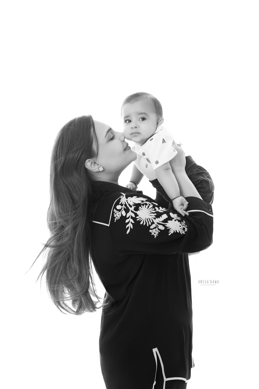 Capture the tender love between Mumma and her son in a sweet kissing pose against a pristine white backdrop with Anega Bawa Photography in Delhi and Gurgaon. Let every moment be a testament to the bond that binds your family together forever.