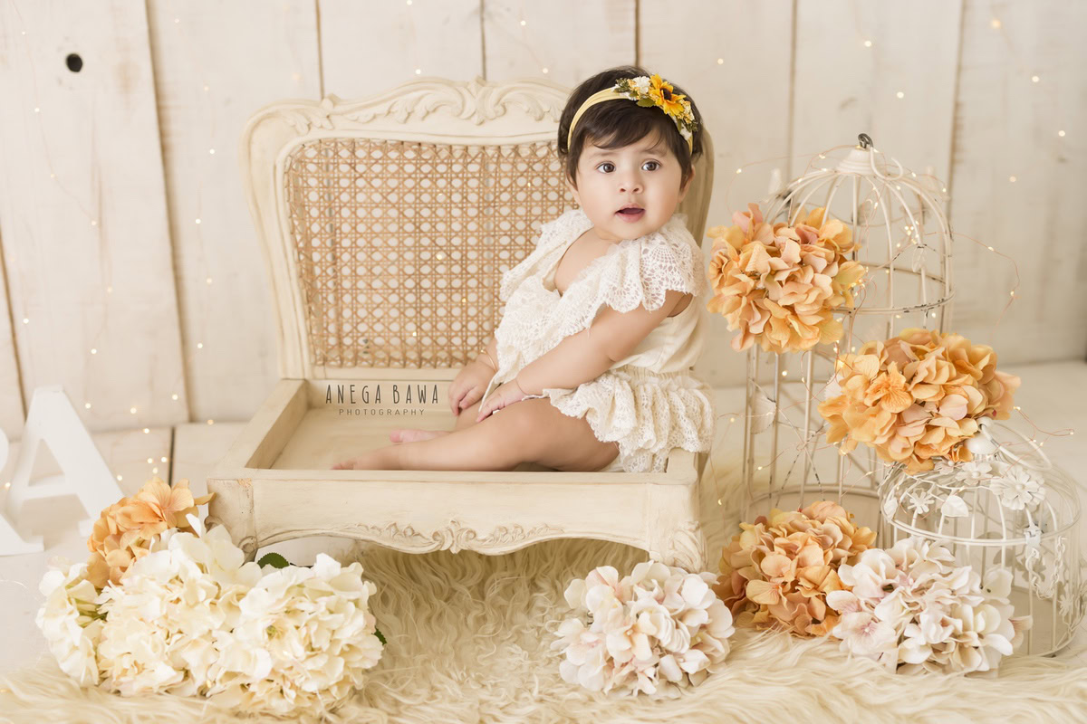 Experience the wonder of a baby pre-birthday photoshoot in Delhi, Anega Bawa, Gurgaon, and Noida as an 8-month-old girl graces a chair. Capture her innocence and charm in this delightful scene, celebrating the milestones of her first year with timeless elegance.
