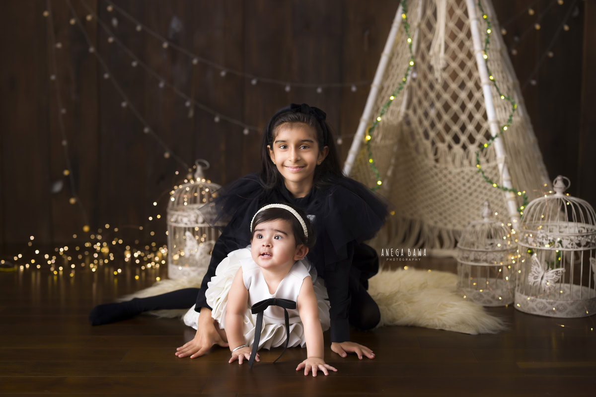 girl-sibling-net-tent-white-castles-golden-lights-brown-backdrop-14-months-1-year-old-toddler-photoshoot-in-delhi-anega-bawa-gurgaon-noida