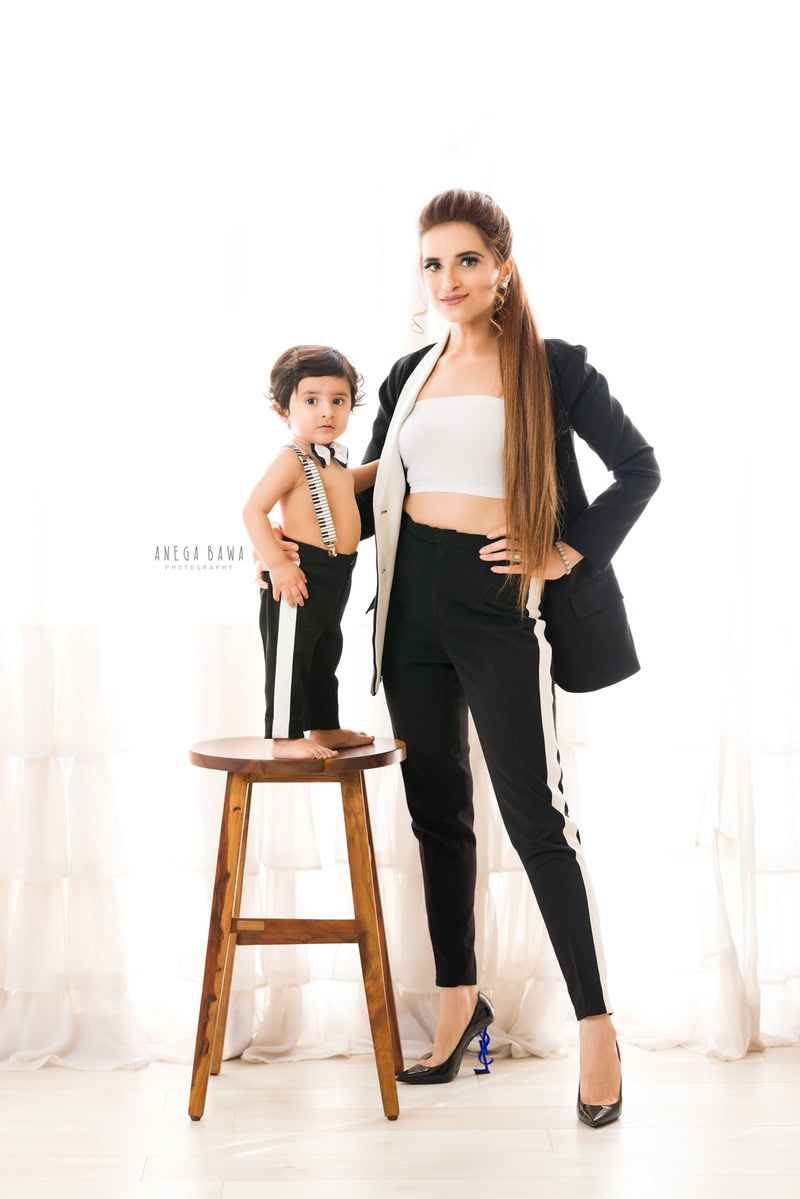 Adorable 1-year-old boy posing with mom against a white backdrop, captured by Anega Bawa Family Photographer Gurgaon (Delhi NCR).