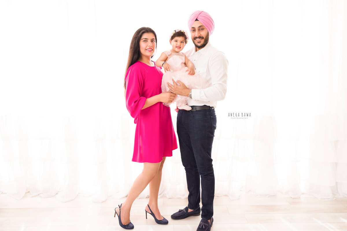 1-year-old girl poses with mom and dad against a white backdrop, family photoshoot by Anega Bawa, Gurgaon (Delhi, NCR)