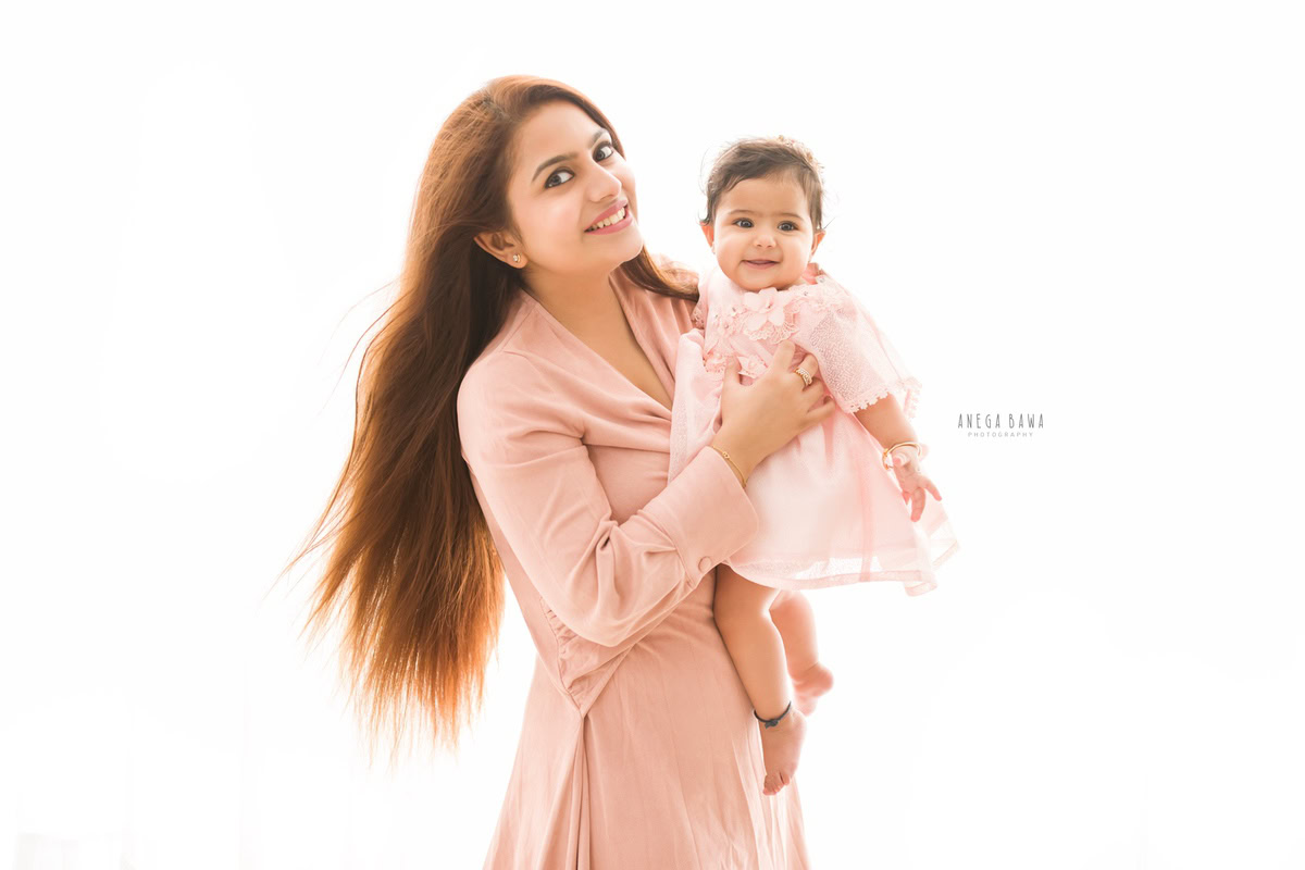1-year-old girl posing with mom against a white backdrop, family photoshoot by Anega Bawa, Gurgaon (Delhi, NCR)