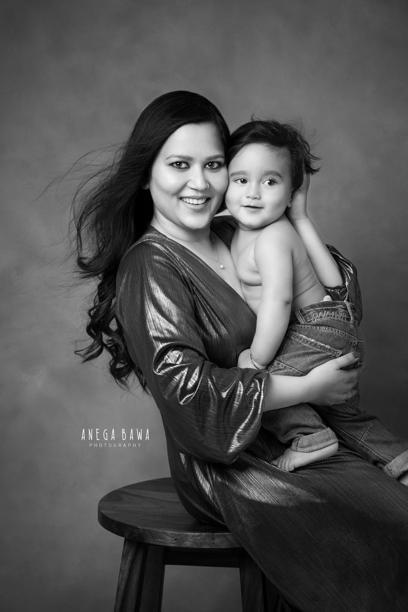11-month-old boy posing cutely with mom against a black and white backdrop, captured by Anega Bawa in Gurgaon (Delhi, NCR)