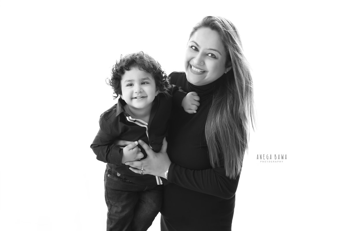 14-month-old boy posing cutely with mom, both dressed in black, against a black and white backdrop, photographed by Anega Bawa in Gurgaon (Delhi, NCR)