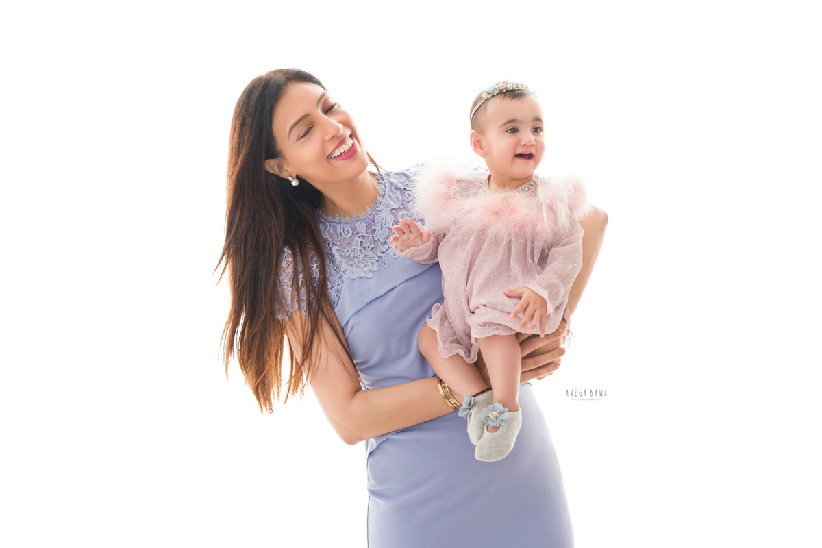 15-month-old girl elegantly posing with her mom against a pristine white backdrop. Professionally captured by Anega Bawa Photography, Gurgaon (Delhi NCR).
