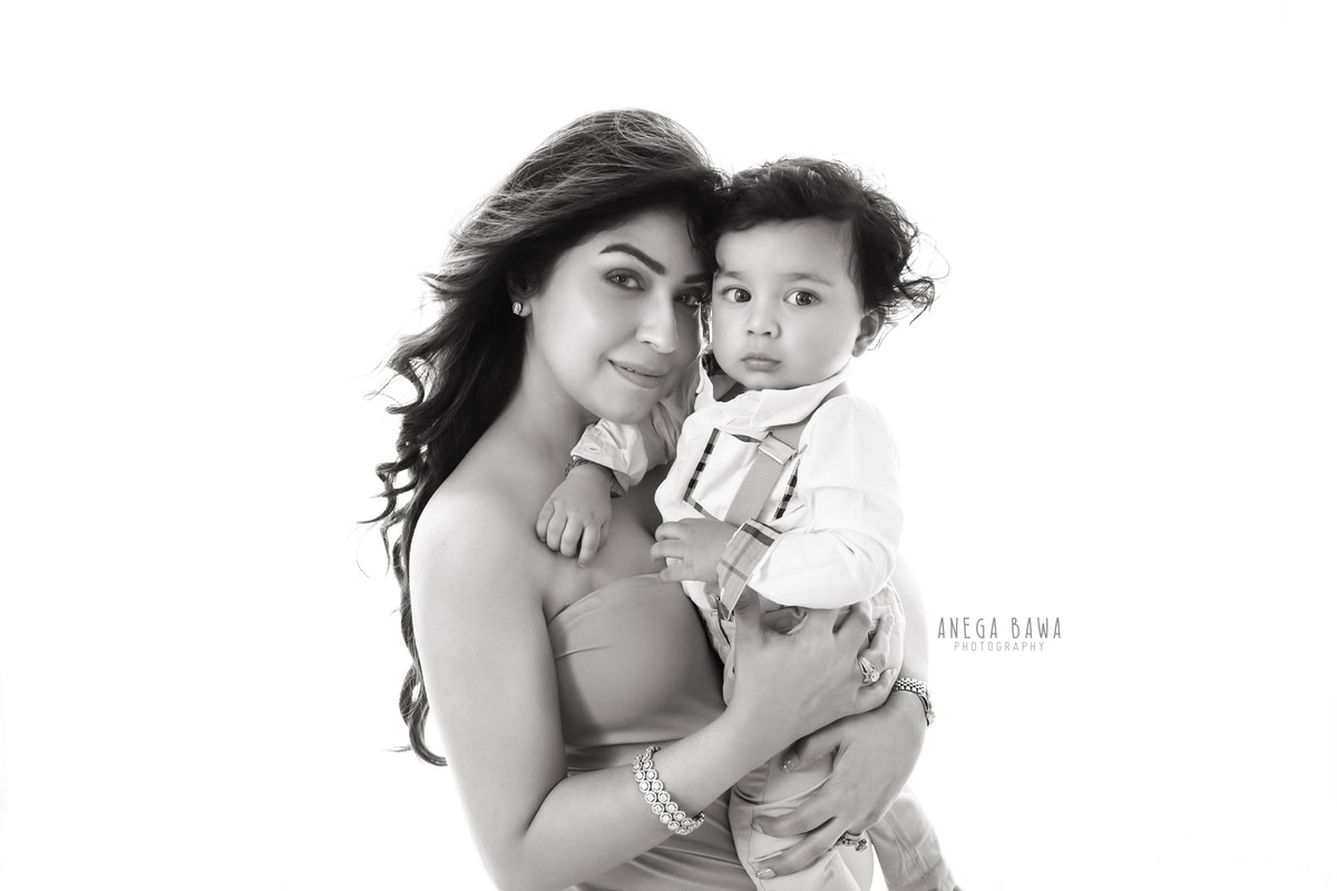 6-month-old son posing in mom's arms against a white backdrop, family photoshoot by Anega Bawa, Gurgaon (Delhi, NCR)