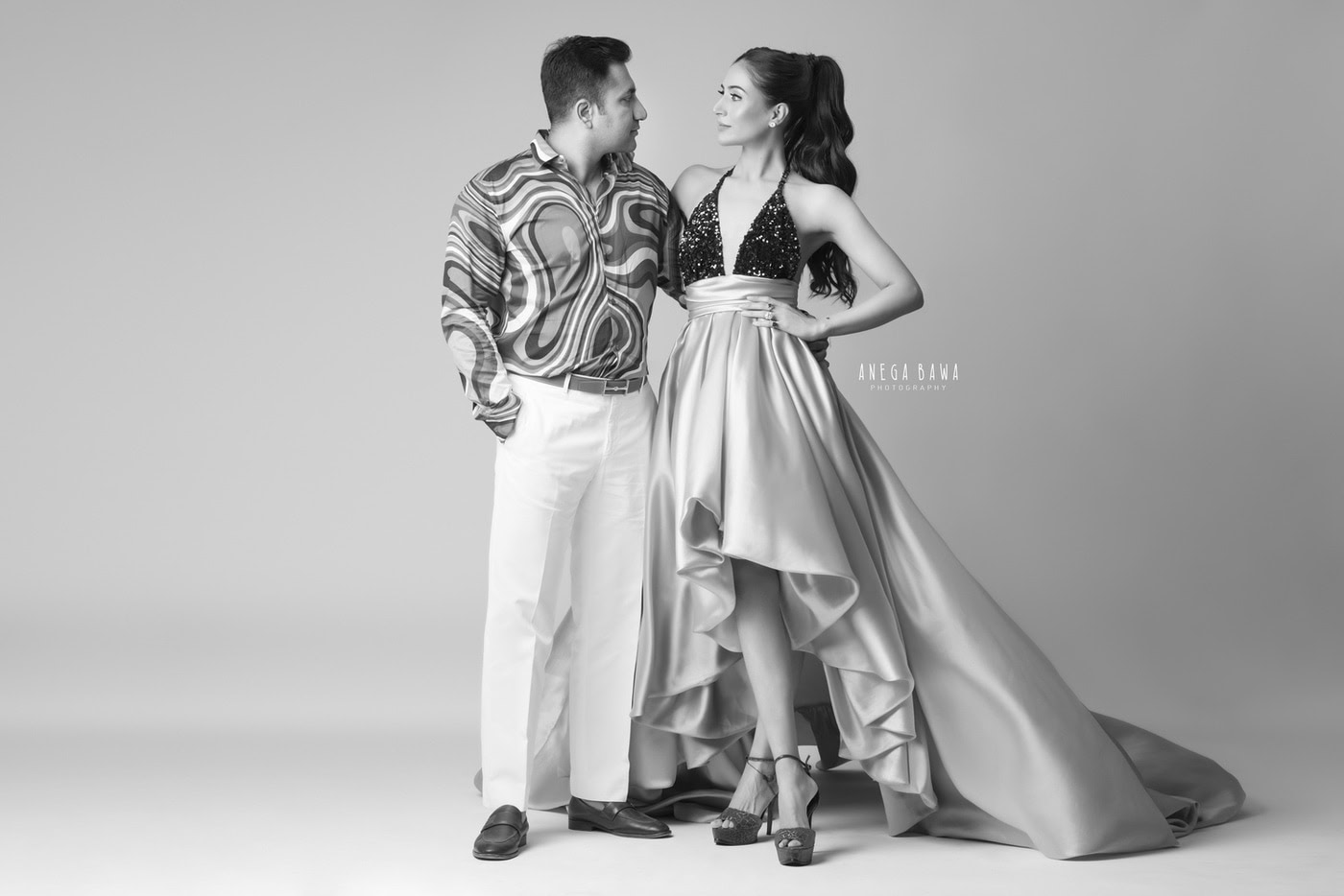 Elegant couple portrait in stylish fashion, black and white photography by Anega Bawa, professional wedding and portrait photography services.