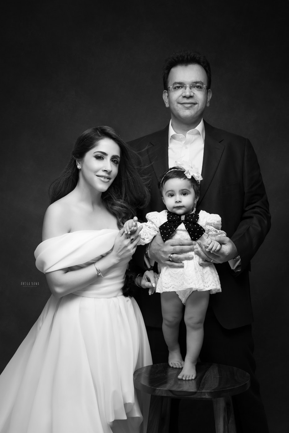 Elegant black and white family portrait featuring parents and a young child, captured by Anega Bawa Photography, showcasing professional family and portrait photography expertise.