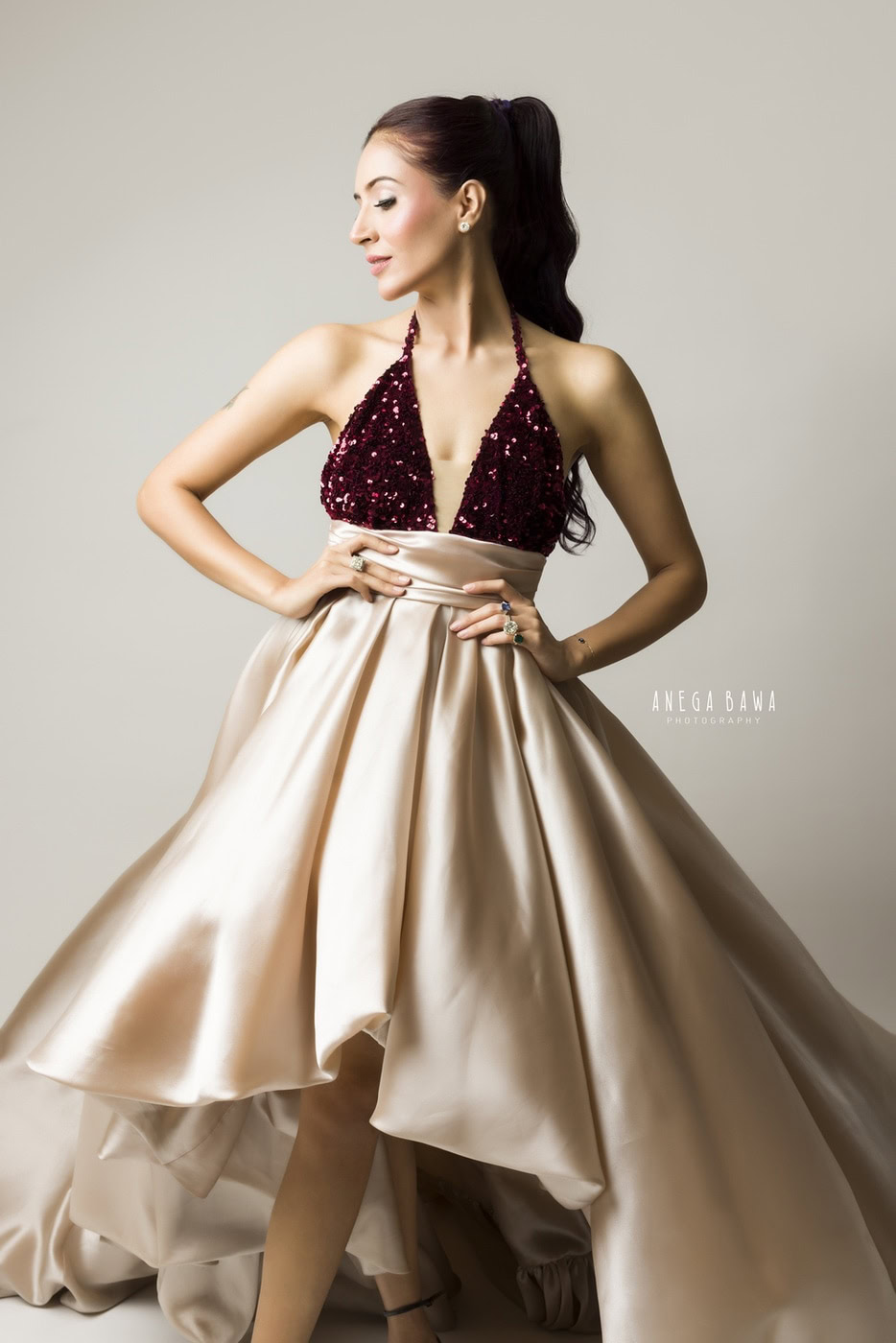 Elegant fashion portrait of a woman in a glamorous gown, photography by Anega Bawa, showcasing high-end fashion and bridal photography techniques, studio shoot with professional lighting.