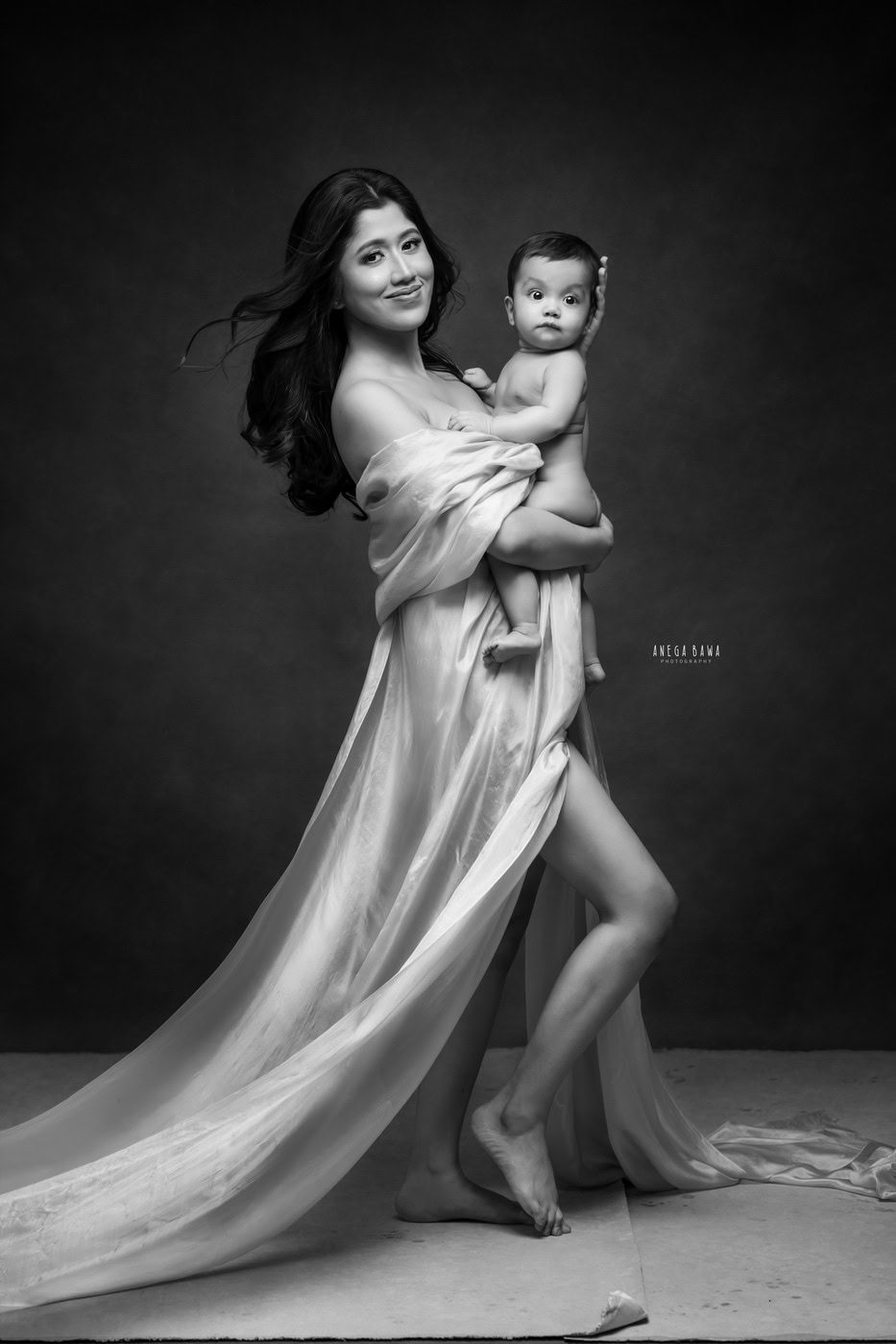 Elegant black and white portrait of a mother holding her young child, capturing motherhood and family love, taken by Anega Bawa Photography.