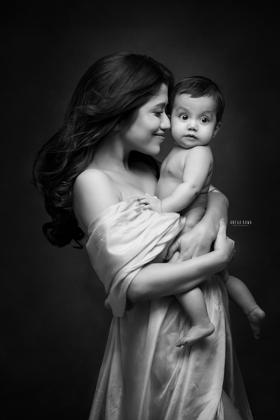 Mother holding her baby, black and white portrait, intimate family photography with emotional connection, professional pregnancy and newborn photography service.