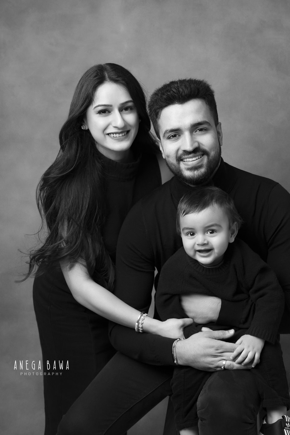 Happy family portrait, black and white, professional photography, capturing love and joy, family photo session, Anega Bawa Photography, memorable family moment, studio portrait, high-quality image, timeless family photography.