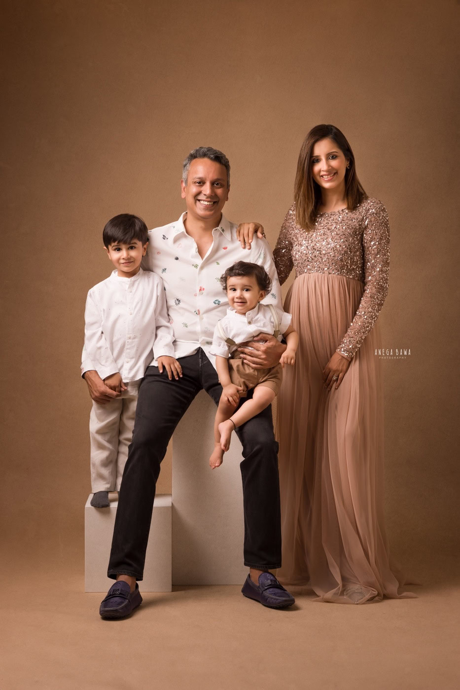 Vibrant family portrait featuring parents and children in elegant clothing, professional studio photography highlighting family bonds and smiles.