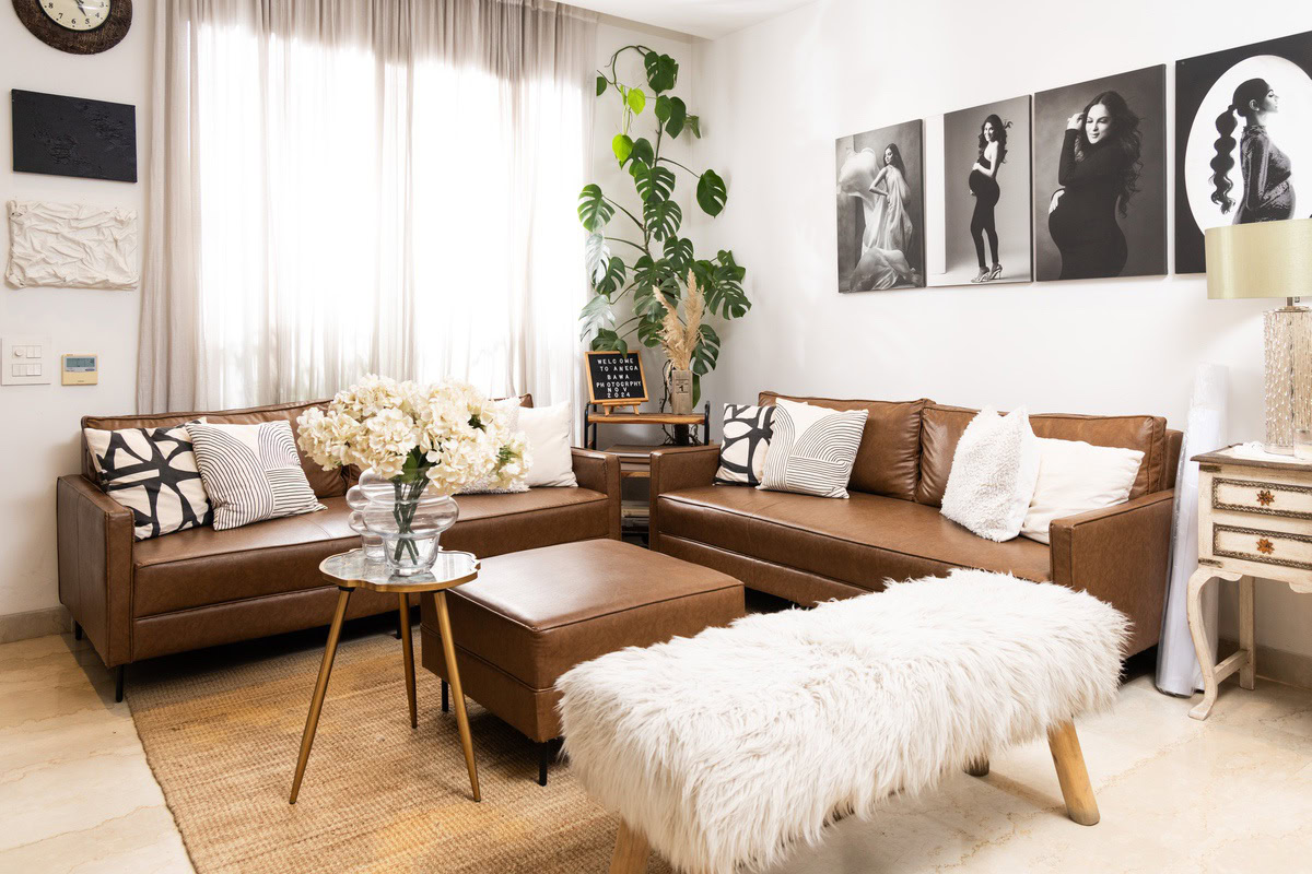 Contemporary living room with leather sofas, black and white art, and cozy decor, ideal for home photography and lifestyle shoots.