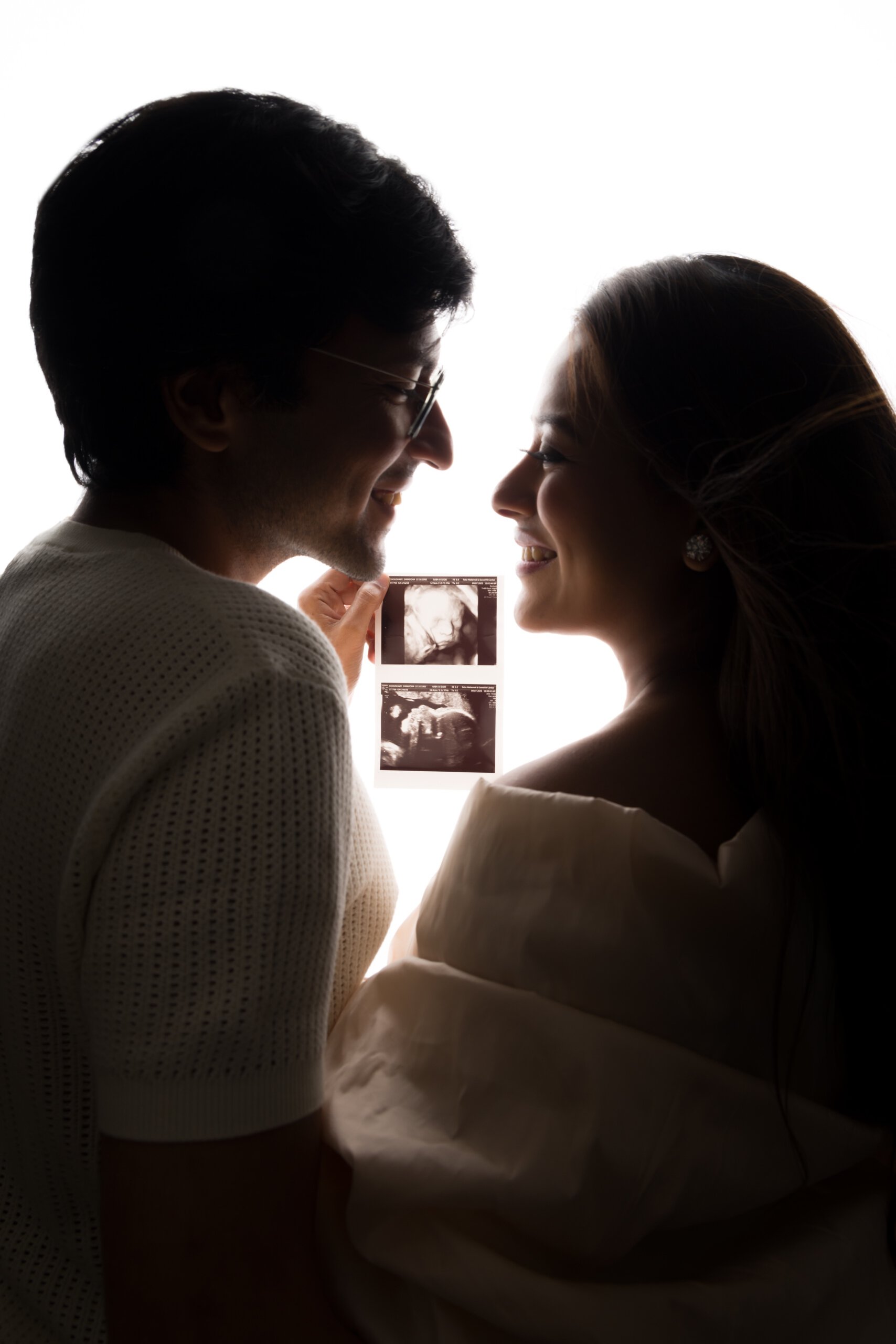Expectant couple holding ultrasound scans