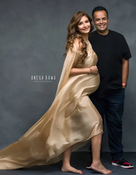 Couple portrait: husband in a black tee and jeans with red sneakers, wife in a champagne satin one-shoulder drape with a long flowing tail