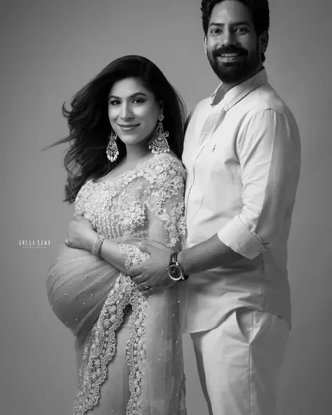 Pregnancy photoshoot in Delhi: black and white portrait of a couple, wife in an embellished net saree and husband in a white shirt with his